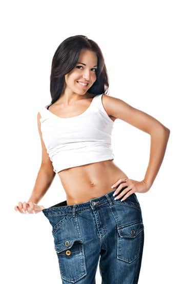 Lose Weight Effectively, Woman demonstrating weight loss by wearing an old pair of jeans.